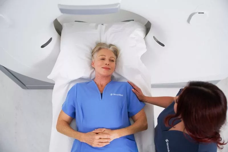 Patient and SimonMed clinician at a CT scanner